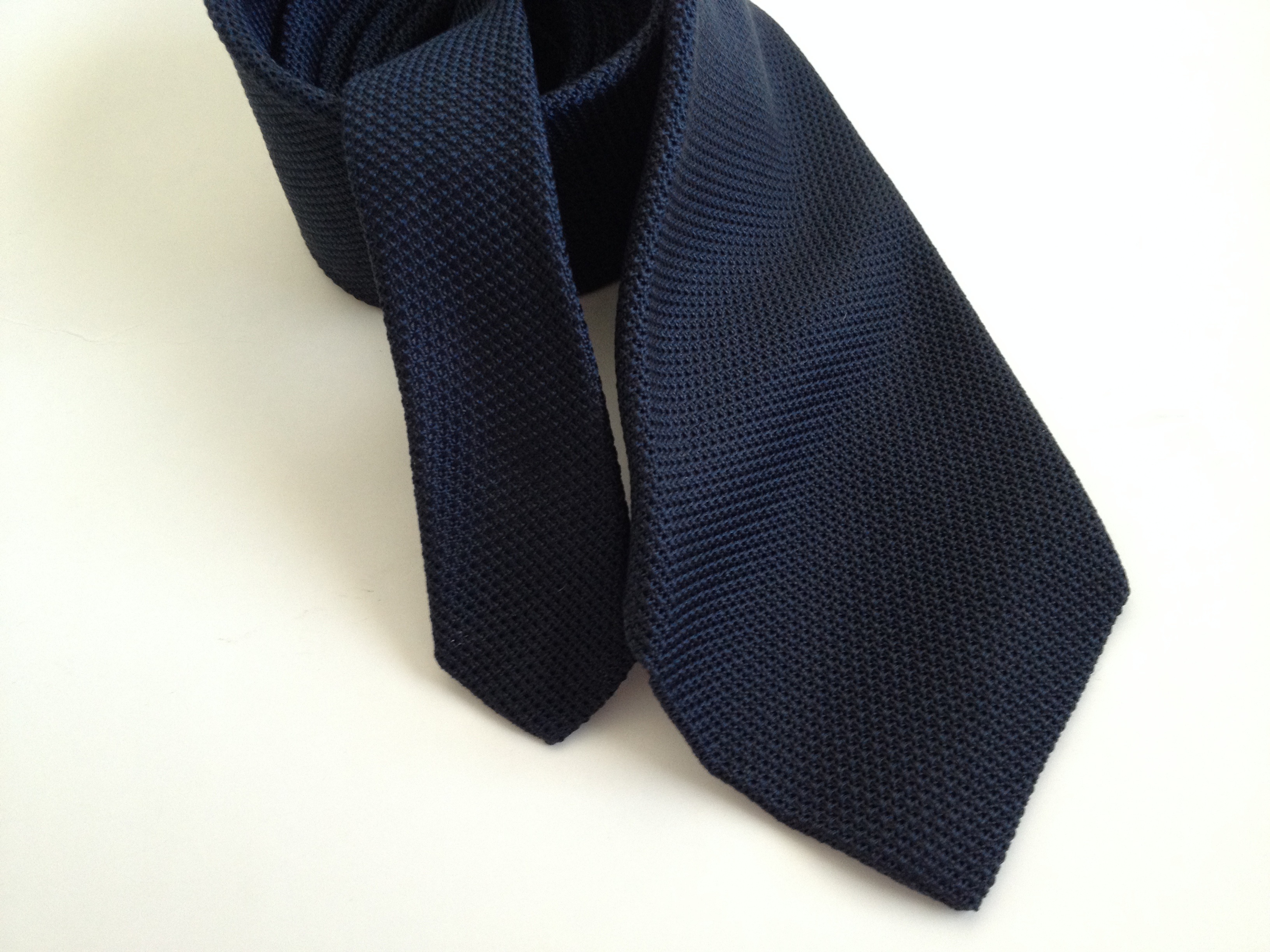 Тёмно-синий вязаный галстук с острым низом универсален, так как подходит к костюму любой степени формальности (кроме смокинга, конечно)